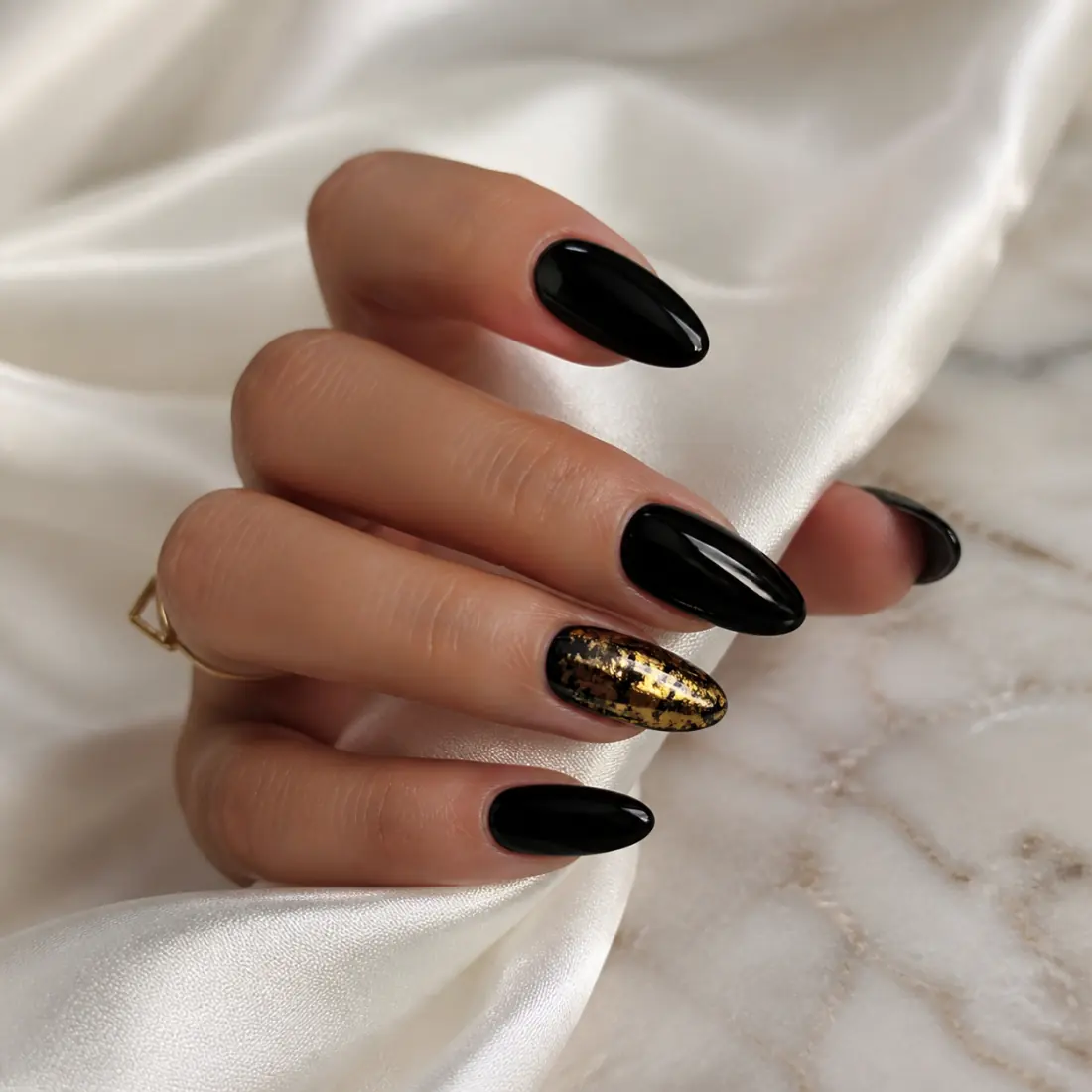 Glossy black manicure with gold foil detail